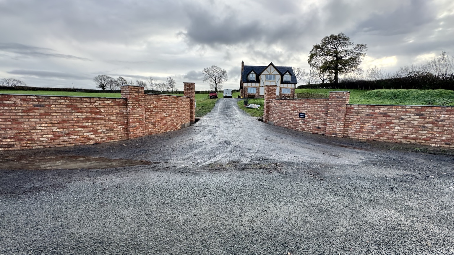 Completed pair of curved brick walls framing the driveway