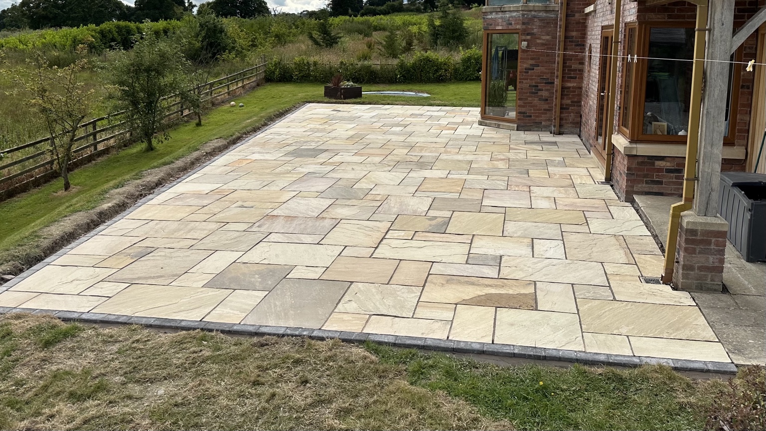 Large Indian sandstone patio beside a house